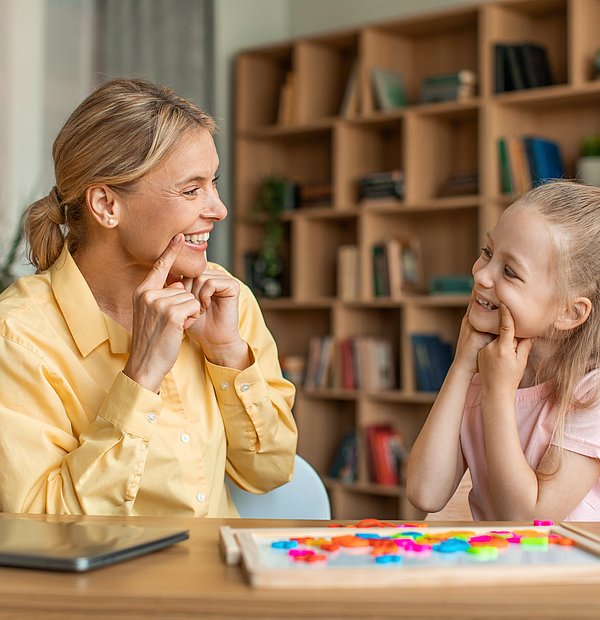 Logopädin und Mädchen bei der Therapie