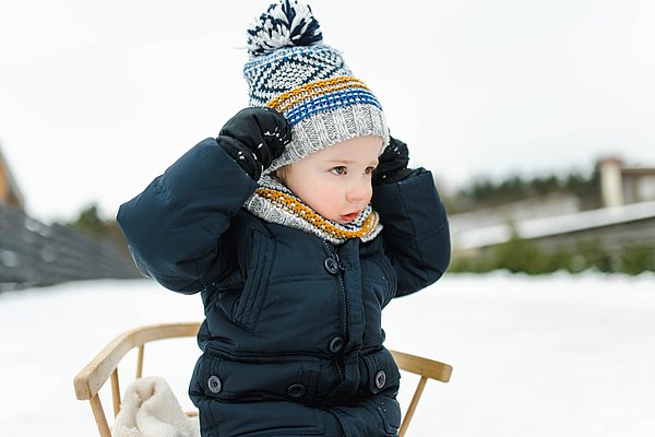 Kleiner Junge mit Mütze im Schnee